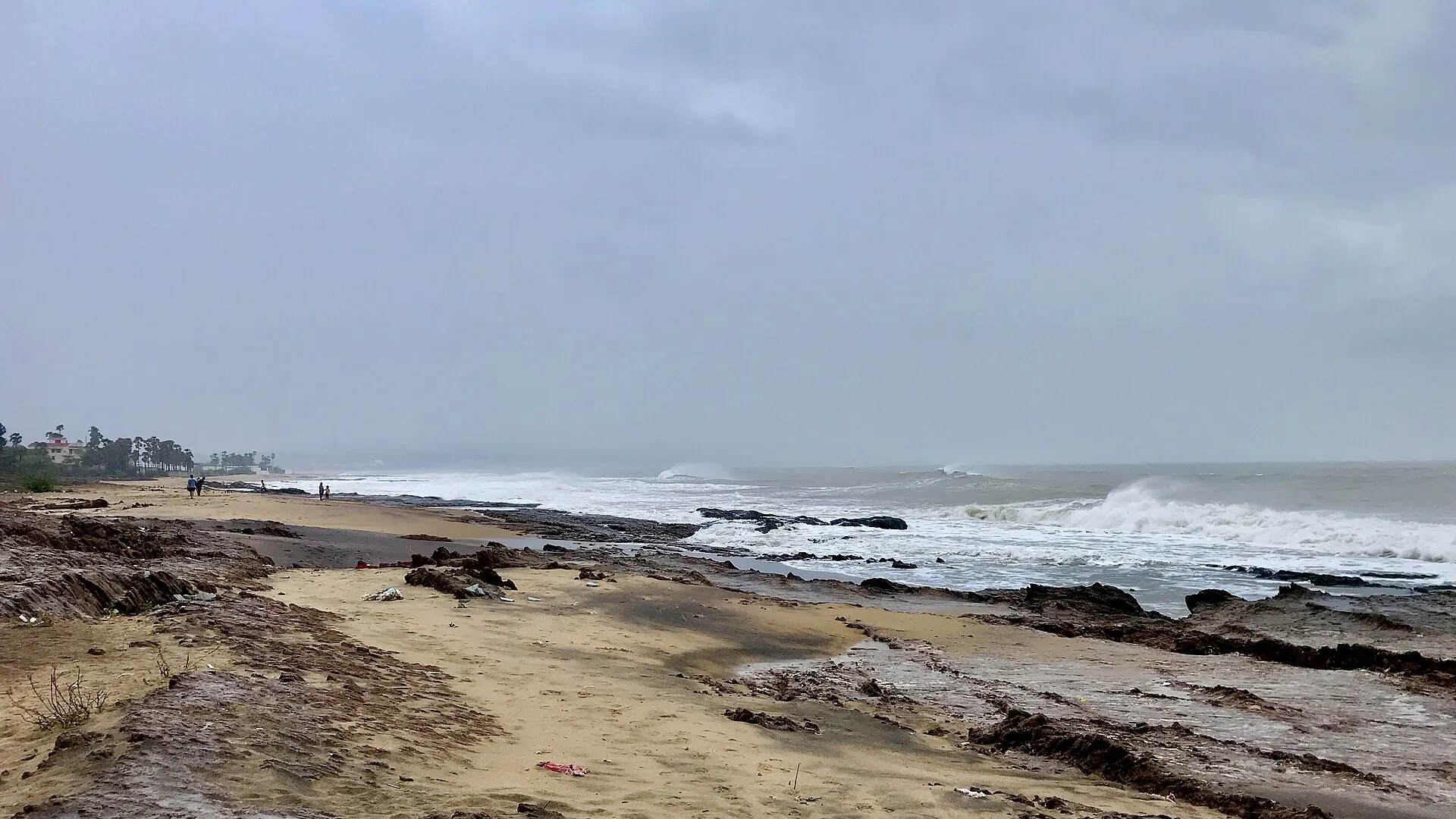 High waves break on the rocky shore at Thotlakonda beach near Visakhapatnam under a grey sky during Cyclone Fani in May 2019