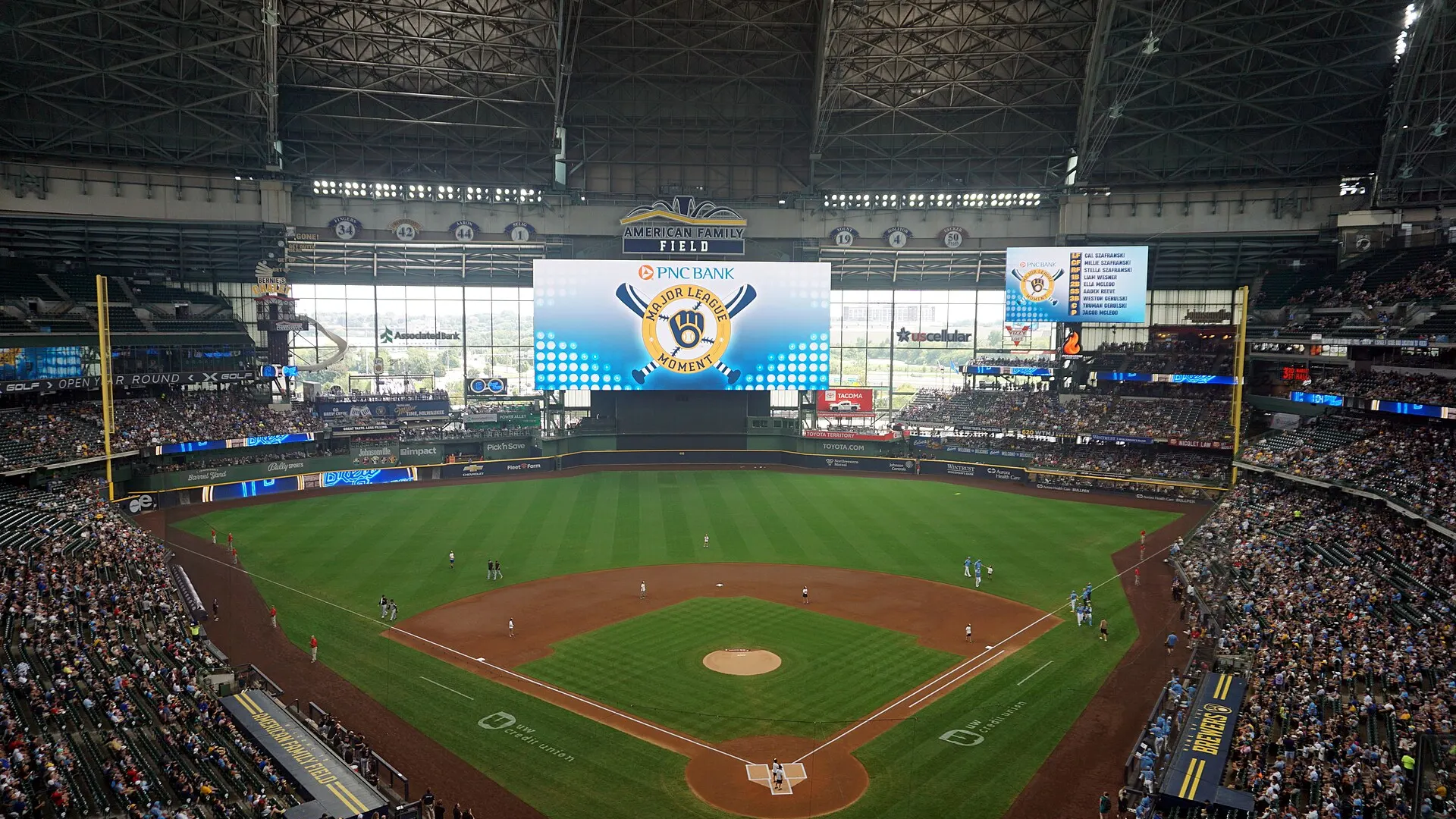 Wide view from the upper deck of American Family Field in Milwaukee, with fans in the stands and the scoreboard above centre field
