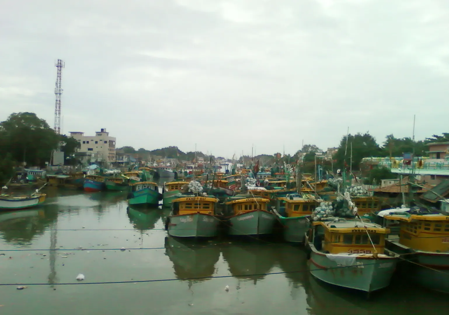 Fishing boats moored side by side at the jetty of Kakinada fishing harbour in Andhra Pradesh, India