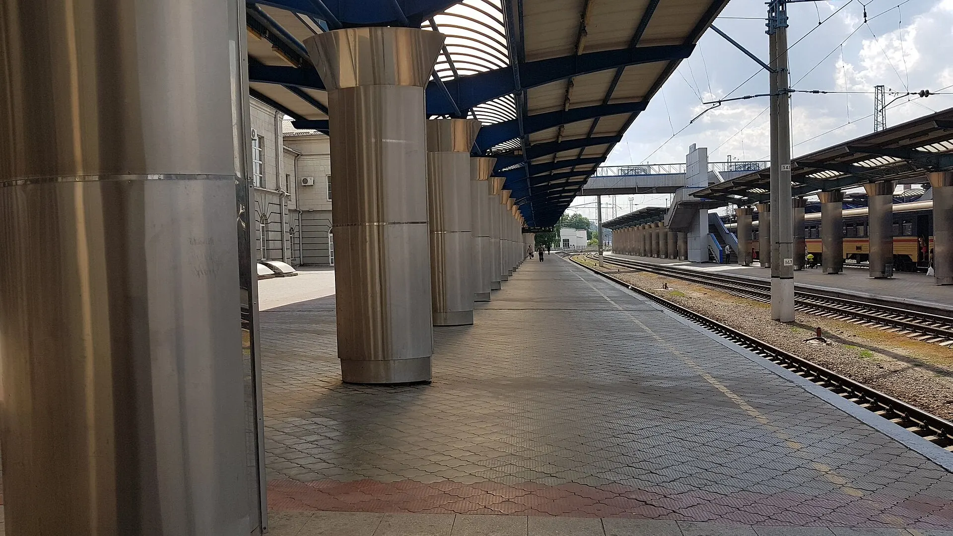 Passengers and carriages on an open platform under canopies at the central railway station in Dnipro, Ukraine, photographed in 2019