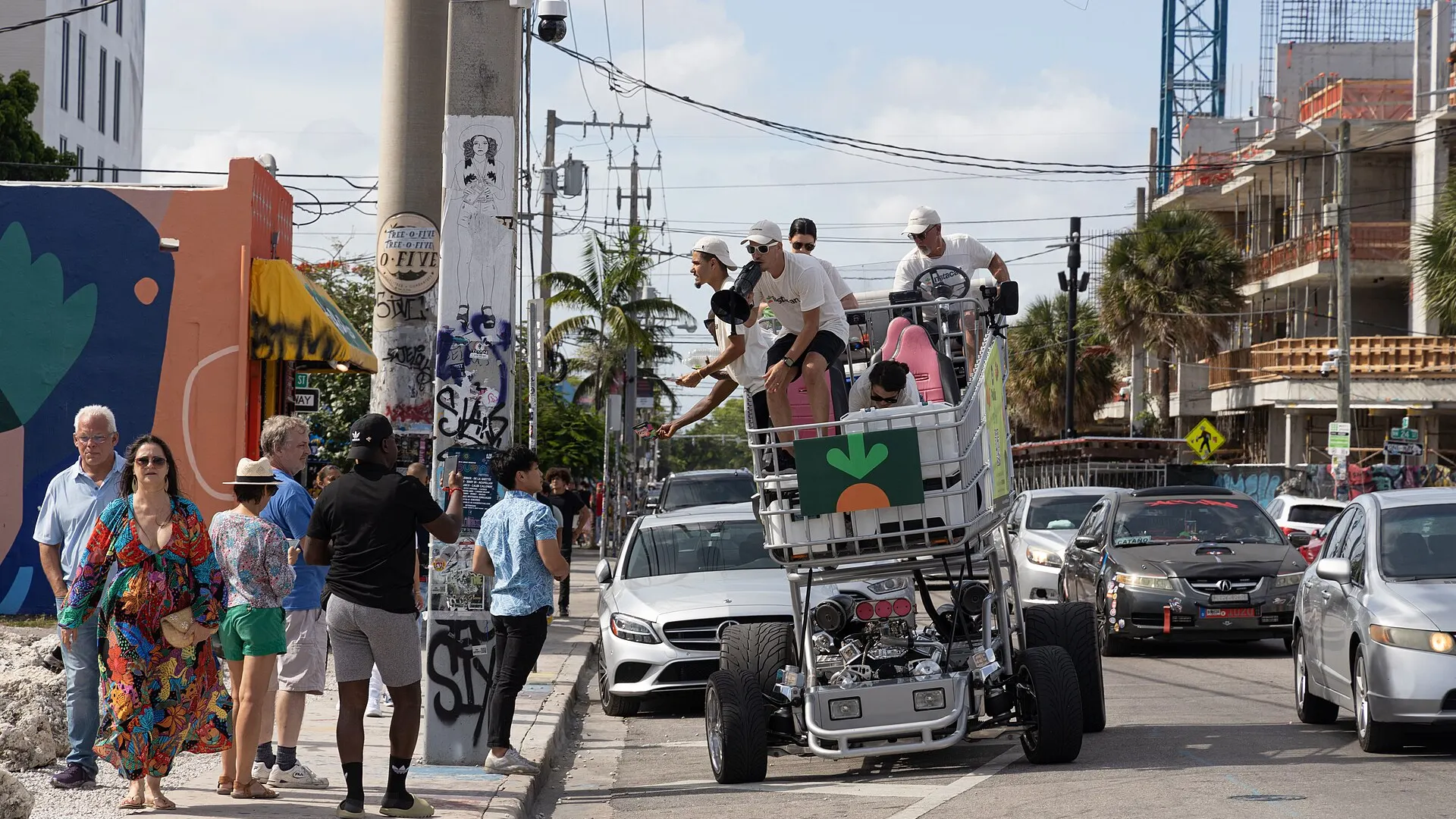 An oversized motorised shopping cart carrying Instacart branding and riders drives down a busy street in Miami, Florida