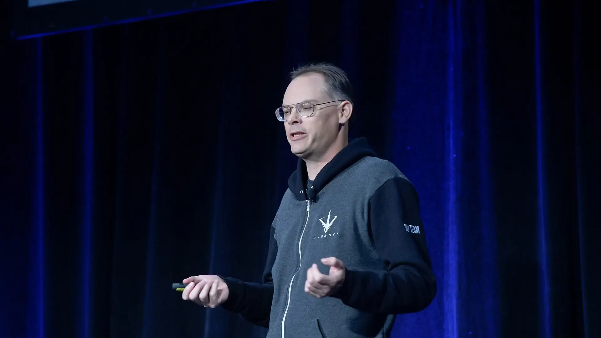 Epic Games founder Tim Sweeney, wearing glasses and a grey hooded sweatshirt, speaks on stage at the Game Developers Conference in San Francisco in 2016