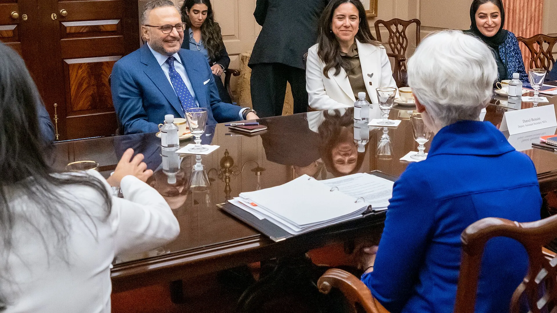 Anwar Gargash, in a blue suit and glasses, smiles across a polished conference table during a meeting with US officials in Washington in 2021
