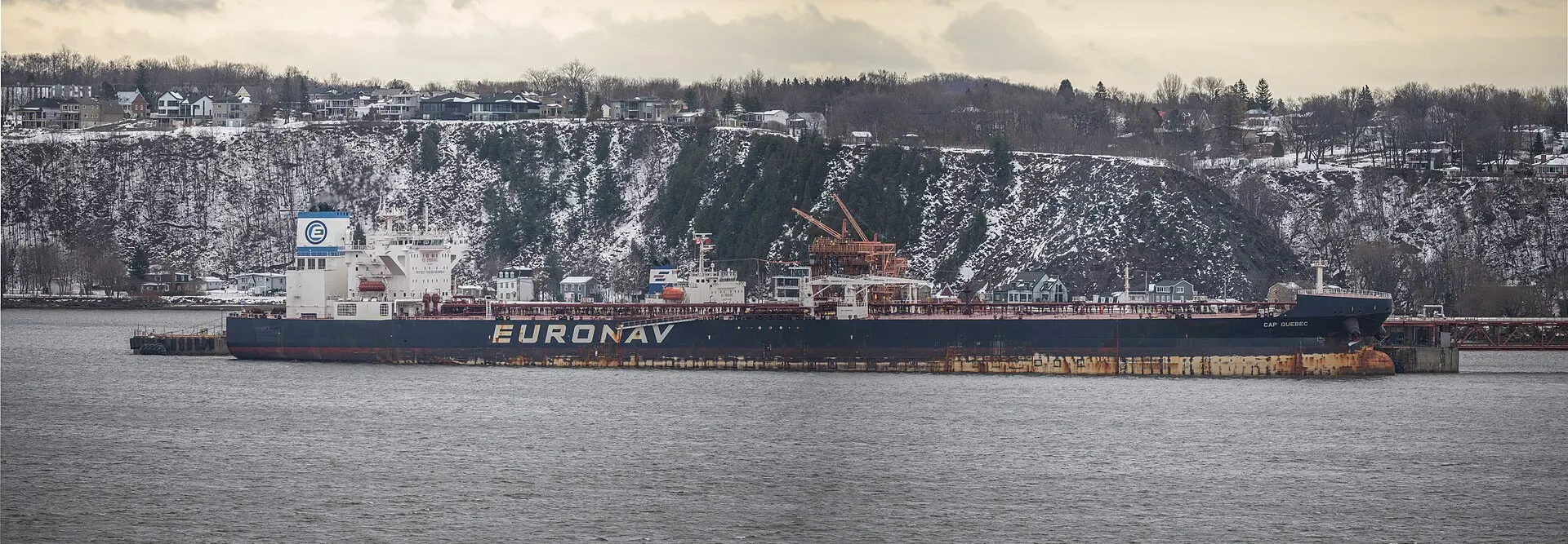 A large crude oil tanker moving along a wide river under a pale sky, shown as a file image of the type of vessel at issue