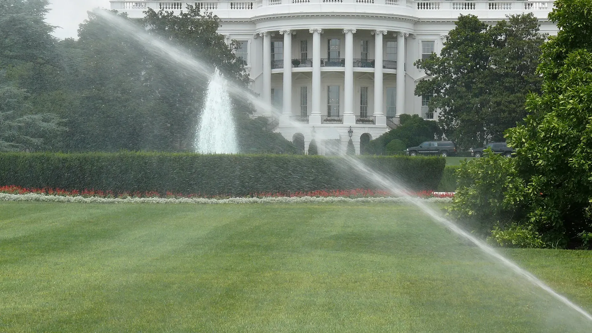The south facade of the White House in Washington, seen across the South Lawn under a clear sky.